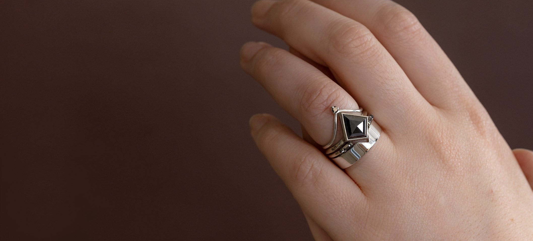 Black Diamond Engagement Ring in 14K White Gold on Model with Burgundy Background