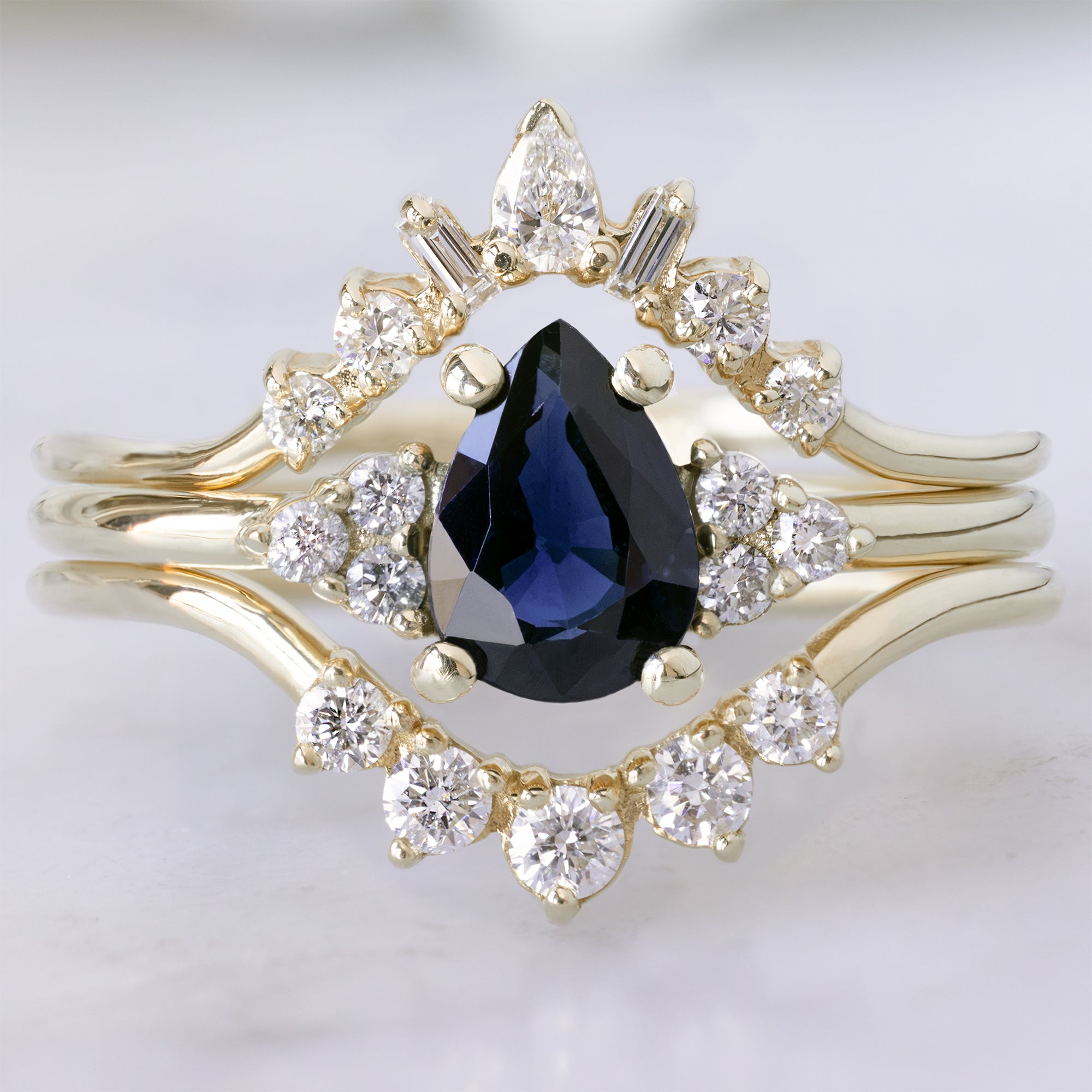 buy:geometric-white-diamond-sunburst-stacking-band-14k-or-18k-yellow-gold,the-ivy-ring-with-a-0-90ct-pear-blue-sapphire-in-14k-yellow-gold,round-white-diamond-sunburst-stacking-band-14k-or-18k-yellow-gold